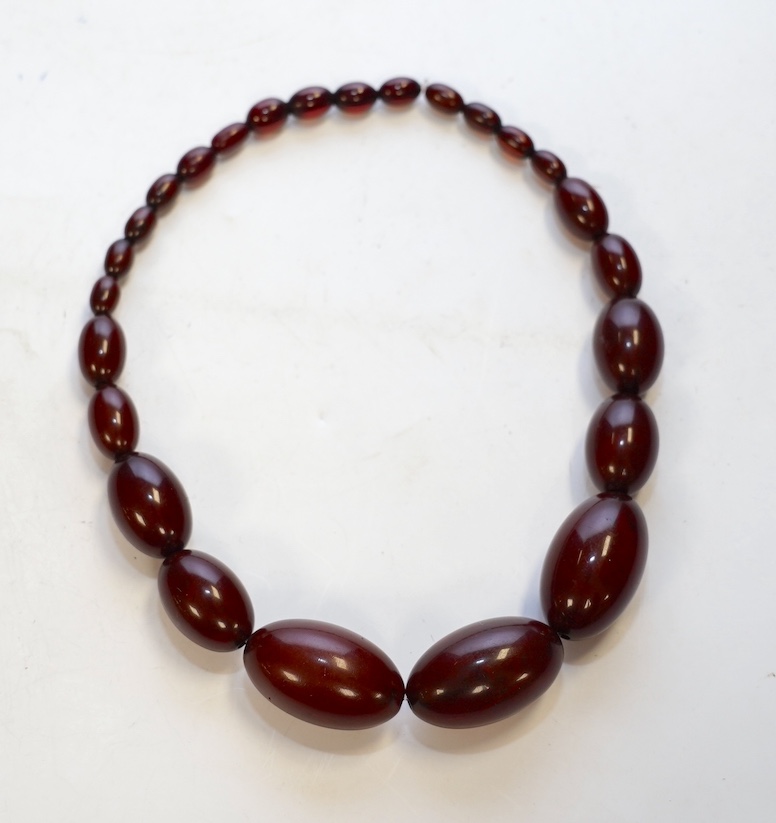 A single strand graduated simulated cherry amber bead necklace, 38cm, gross weight 65 grams. Condition - fair.